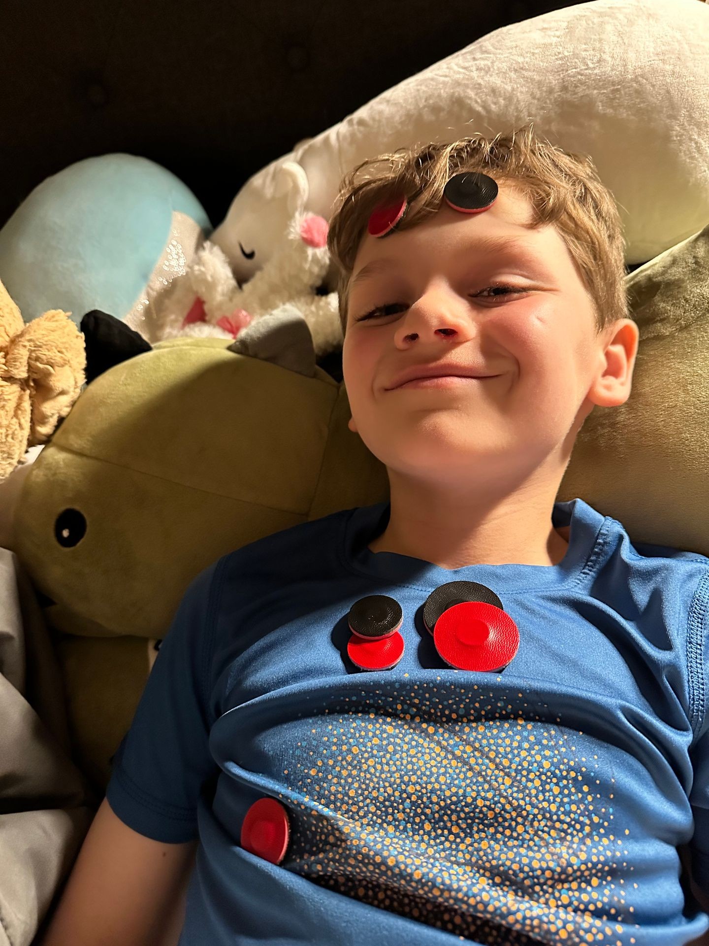 Young boy with magnets on his face and chest.