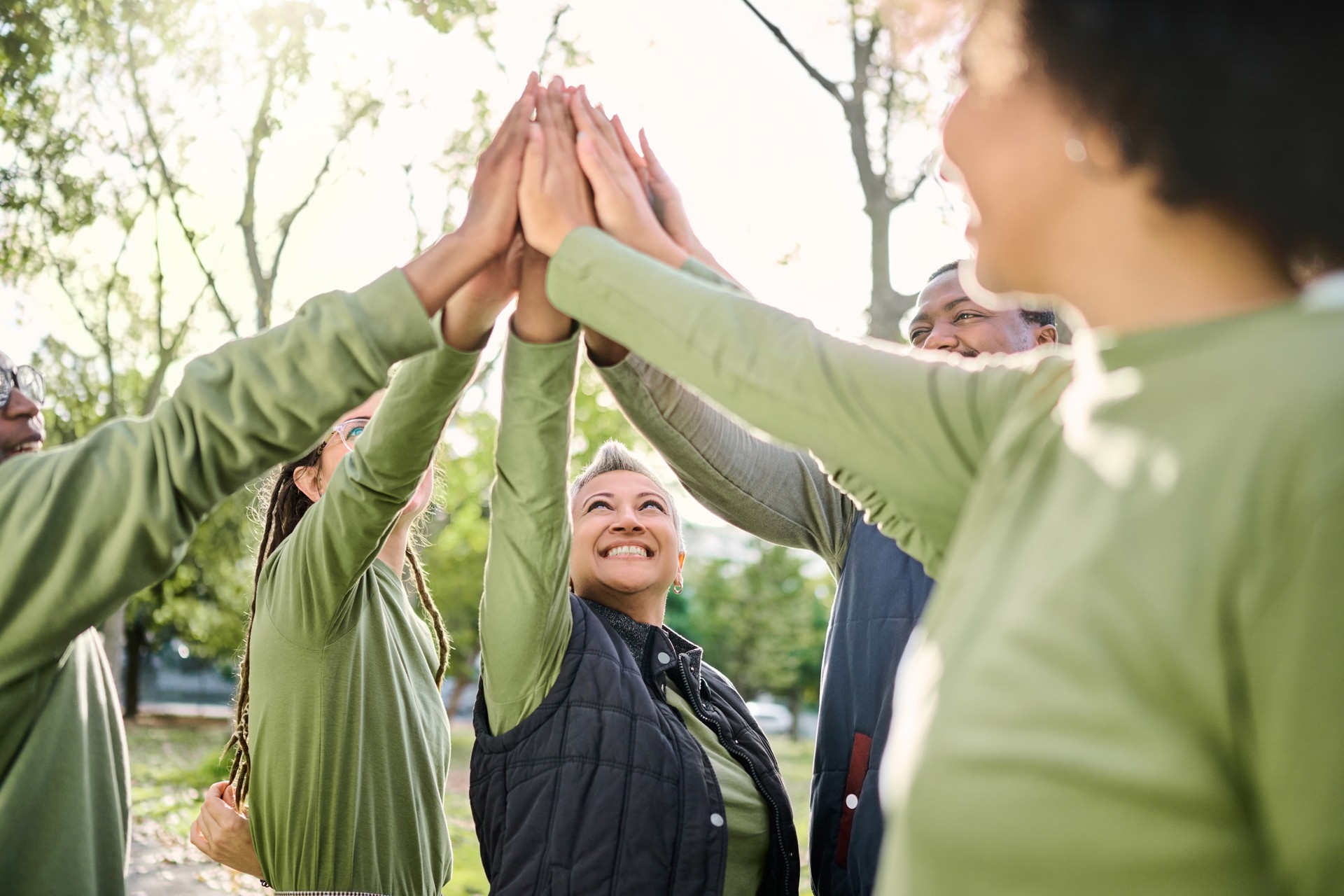 High five, nature and people hands from team building at wellness retreat with community and support. Volunteer, happiness and smile of support group excited with collaboration, trust and solidarity