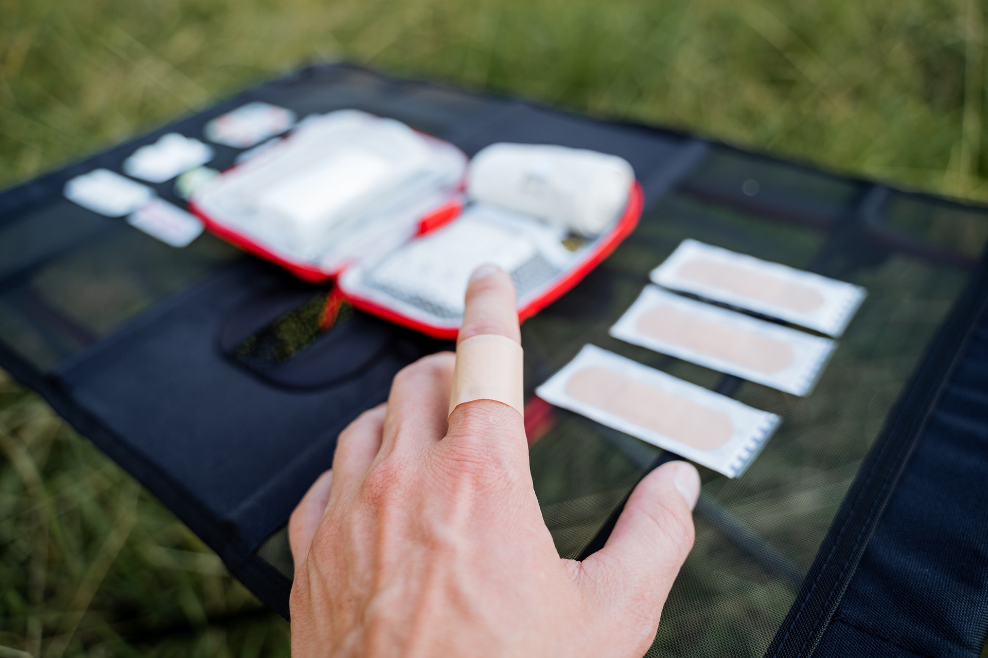 First aid kit for cuts Adhesive plaster glued to the finger, injured finger on the hand, flesh-colored patch, emergency medical care.